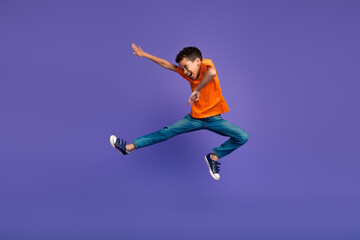 Full size photo of cute small schoolkid jump fight empty space isolated on violet color background
