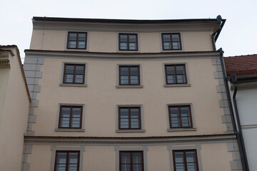 A very large structure that features numerous windows all across its facade, making it appear bright and spacious from the outside