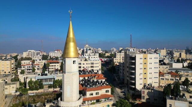 Gold-clad minaret and the skyline of Ramallah, capital of the Palestinian Territories in the occupied West Bank