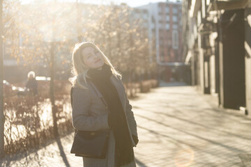 Obraz premium Young stylish hipster girl wearing modern trench coat walking in urban city smiling happy. Caucasian female model 