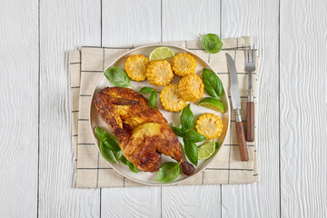 half of bbq chicken with corn cobs coins and basil