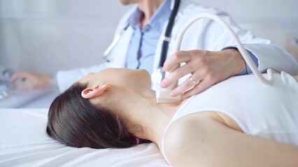 Obraz premium Doctor man is using ultrasound equipment on neck of female patient lying down for a medical examination. Medicine and science
