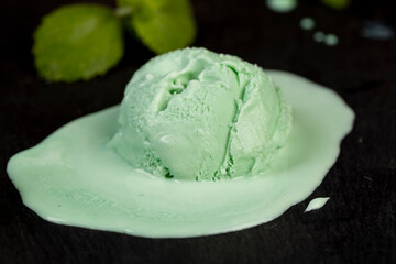 green ice cream with mint flavor on a black slate surface