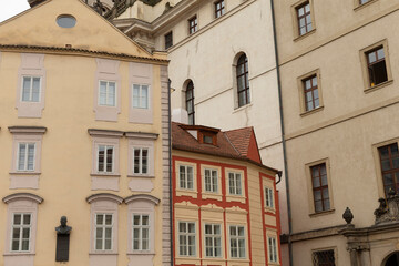 Obraz premium A series of several buildings standing in a row, prominently featuring a striking red building positioned right in the center of the lineup