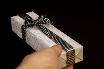 with a black and silver ribbon tied with a silver gift package