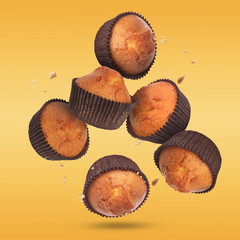Delicious muffins in air on golden background