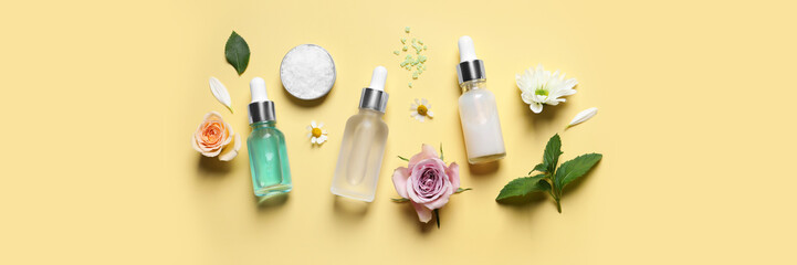 Flat lay composition with cosmetic serums on pale yellow background, banner design. Spa treatment