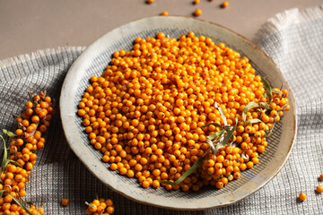 A plate with berries on a table with a gray napkin