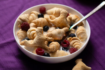 A quick breakfast of small croissants and cookies in the shape of a cat with milk. Halloween breakfast concept