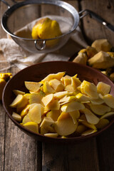 Prepared quince in a bowl for making jam on an old wooden table