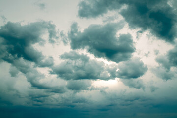 Dramatic sky with turquoise overcast clouds hiding the sun
