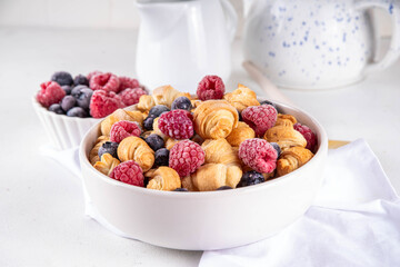 Tiny breakfast croissant cereals with fresh berries and milk