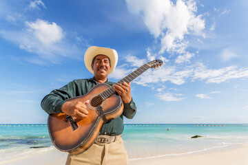 Mexican musician with guitar on the beach, Playa del Carmen, Mexico