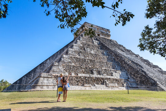 Tourist couple looking at temple, Chichen Itza, Yucatan, Mexico