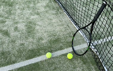Tennis racket and tennis ball on court.