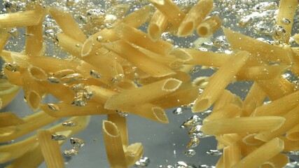 Penne pasta falls into boiling water. Filmed on a high-speed camera at 1000 fps. High quality FullHD footage - Powered by Adobe