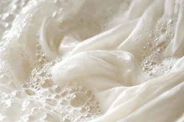 Fototapeta premium A close-up view of a white garment being gently washed in soapy water. The water is filled