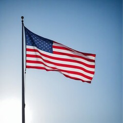 Obraz premium American flag waving against blue sky, symbolizing patriotism and freedom. Ideal for Fourth of July celebrations or national pride campaigns.