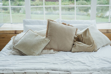 Cozy bedroom setup with soft pillows and blankets in a sunlit room near a garden in spring