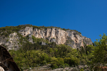 Monte Albano towering rock face, located near Mori, Trentino, Italy, offers stunning views and challenging routes for climbers. The popular via ferrata trail, surrounded by lush greenery.