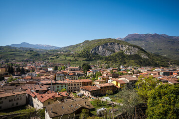Fototapeta premium A stunning view of the town of Mori, Trentino, Italy, captured from Monte Albano via ferrata. The town's red-tiled roofs and surrounding hills create a picturesque scene amidst the mountains.