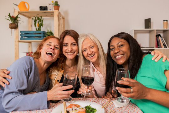 Group of cheerful women having christmas dinner together at home