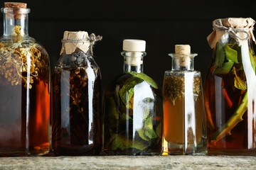 Different tinctures in bottles on wooden table, closeup