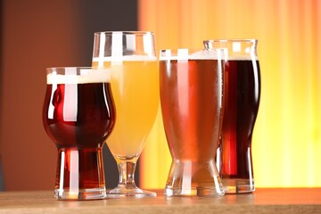 Glasses with different types of beer on wooden table indoors
