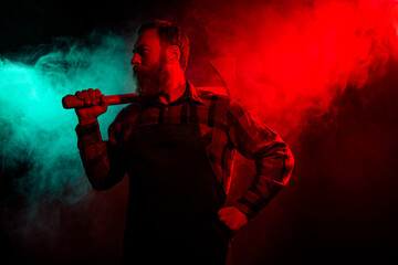 Photo of halloween male angry character hold sharp ax festival carnival isolated on dark misty mysterious background