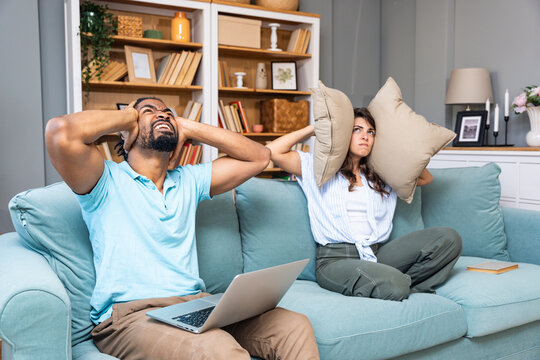 Urban city living issues. Young couple just moved to new apartment having problems with neighbors and low quality noise insulation of construction of the building. Stressed and irritated people.
