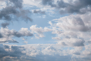 Tranquil blue sky with fluffy white clouds, perfect for nature backgrounds or atmospheric wallpapers.