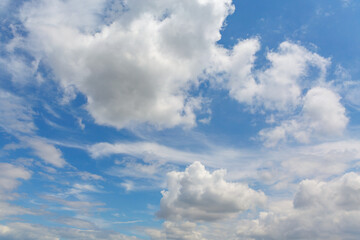 Serene blue sky with fluffy white clouds perfect for background or wallpaper applications
