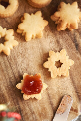 Filling star shaped Linzer Christmas cookie with strawberry marmalade, top view