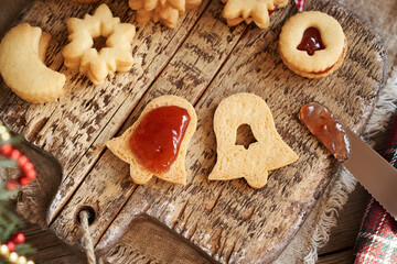 Filling bell shaped Linzer Christmas cookie with strawberry marmalade, top view