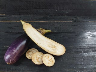 eggplant on a black wooden table. Vegetarian cuisine, Organic farm plant 