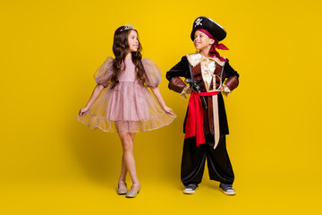 Full size photo of two little kids wear halloween pirate princess costume isolated on yellow color background