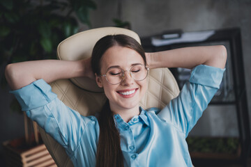 Photo of sweet charming lady assistant wear shirt glasses relaxing arms behind head indoors...