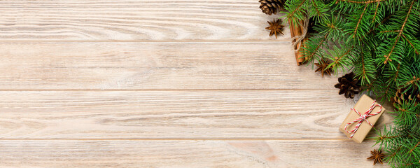 gift boxwith cinnamon sticks, anise stars, pine cones and pine branches on wooden table. Top view. Christmas gifts in woodan style