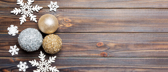 Top view of Christmas balls and creative decorations on wooden background with copy space. New Year concept