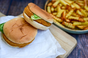   Home made  chicken Burger and   deep fried french fries on wooden   cutingboard 