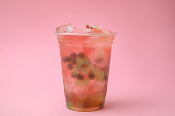 Tasty bubble tea in plastic cup on pink background