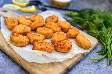Crispy  deep fried   chicken  popcorn  nuggets and french fries . Breaded  with Cornflakes chicken  Breast fillets  with chilly peppers and fresh   basil on wooden rustic background