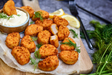 Crispy  deep fried   chicken  popcorn  nuggets and french fries . Breaded  with Cornflakes chicken  Breast fillets  with chilly peppers and fresh   basil on wooden rustic background