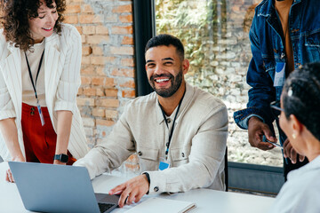 Content businessman leading a vibrant teamwork session with colleagues in a spacious, light-filled...
