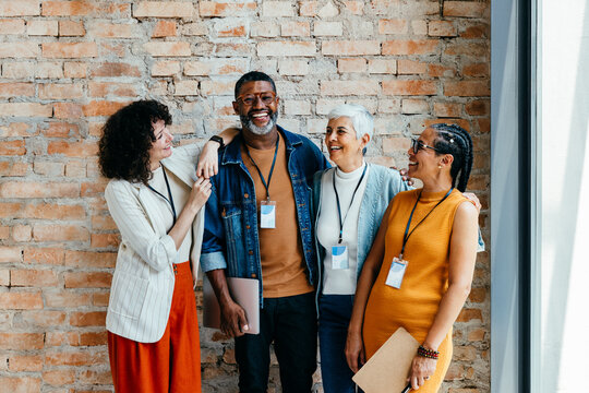 Group of professionals of different ages smiling and standing together