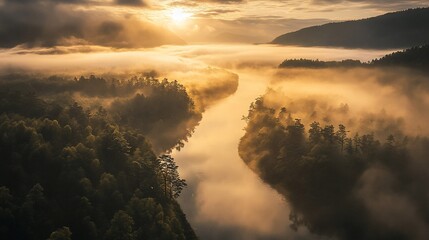 A winding river flows through a misty valley at sunrise, with golden sunlight illuminating the clouds and trees.
