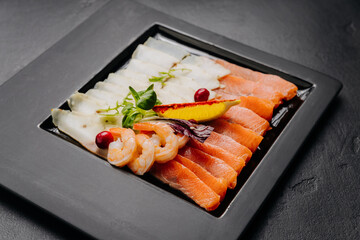 Gourmet seafood platter with fresh salmon, shrimp, and white fish fillet served with herbs and lemon