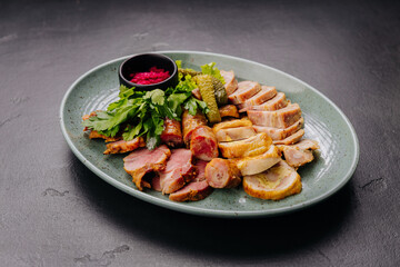 Traditional meat platter with pickles, herbs and beetroot dip on plate. Perfect for gourmet dining