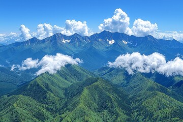 Obraz premium Majestic Mountain Range with Snowy Peaks and Fluffy Clouds in Blue Sky