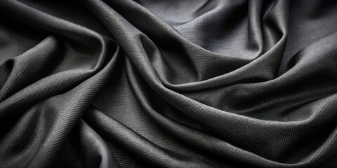 Fototapeta premium The smooth, elegant folds of a black fabric, revealing a delicate texture and soft sheen.